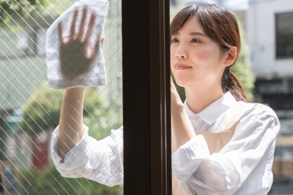 窓掃除をするエプロン姿の女性