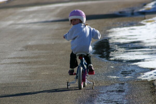 ヘルメットをつけて自転車にのる幼い女の子